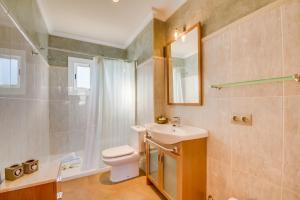 ein Badezimmer mit Waschbecken, Toilette und Spiegel in der Unterkunft Ideal Property Mallorca - Lago Miguel in Port d'Alcúdia + 26 Fotos