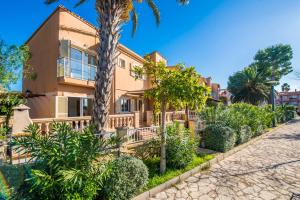 een huis met palmbomen ervoor bij Ideal Property Mallorca - Lago Miguel in Port d'Alcudia