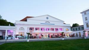 un grande edificio bianco con ombrelloni di fronte di Grand Hotel Heiligendamm - The Leading Hotels of the World a Heiligendamm