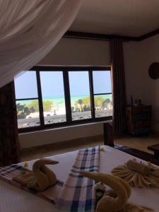a bedroom with a bed with a view of the ocean at White Sands in Paje