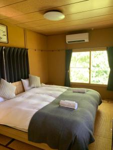 a large bed in a room with a window at Sai's House Hakuba in Hakuba