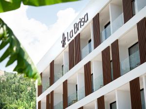 a building with a sign on the side of it at La Brisa Boutique Hotel in Dhërmi