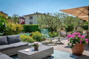 a patio with a couch and a table and flowers at Hotel San Marco in Lucca