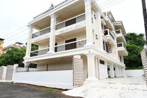 ein weißes Gebäude mit Balkonen darauf in der Unterkunft Visao in Velha Goa