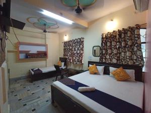 a bedroom with two beds and a table in a room at Hotel Aakash Ganga in Varanasi