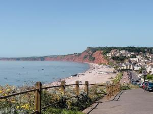 una playa con gente en el agua y edificios en Salters Cottage - Stunning Modernised 3 BR Home Just Steps From the Beach, en Budleigh Salterton