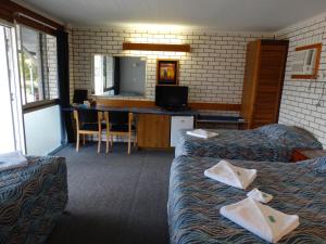 um quarto de hotel com duas camas e uma televisão em Gayndah A Motel em Gayndah