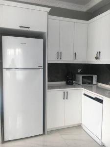 uma cozinha com armários brancos e um frigorífico em Cheerful villa in Kocaali 80 m from sea em Yukarı Kocaali