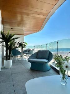 Una sala de estar con un sofá azul y la playa. en FIRST RESIDENCe, en Mamaia