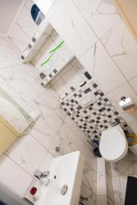 a white bathroom with a toilet and a sink at Apartman Studio Blue in Subotica +14 photos