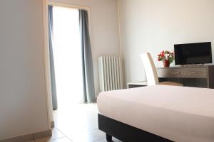 sypialnia z łóżkiem, biurkiem i telewizorem w obiekcie Hotel Savoia w mieście Poggio Rusco