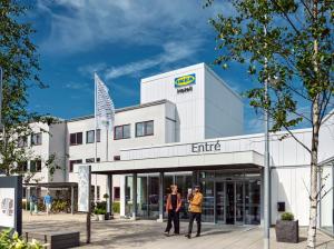 艾尔姆胡尔特宜家酒店的两个人站在一座建筑前面