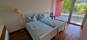 Cette chambre comprend un lit avec des draps bleus et un balcon. dans l'établissement Senevita Wangenmatt, à Berne