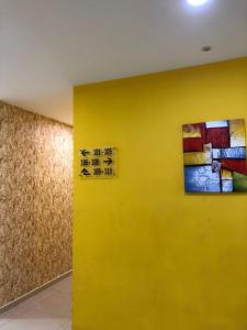 uma parede amarela com um sinal. em M Design Hotel@KLIA,Sepang em Sepang