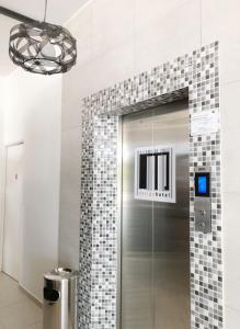 セパンにあるM Design Hotel@KLIA,Sepangのタイル張りの壁のバスルーム(ガラス張りのシャワー付)