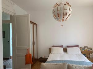 a bedroom with a bed and a chandelier at Persévérance in Dinard
