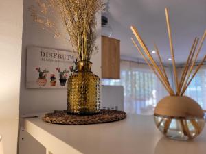 a gold vase sitting on a counter with some grass at "COZY LOFT", TERRACE, PARKING and SWIMMING POOL in Málaga