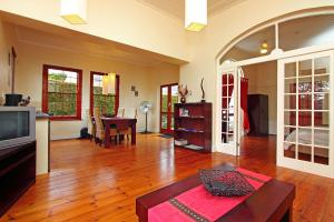 un soggiorno con televisione e tavolo di Cape Paradise Lodge and Apartments a Città del Capo