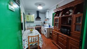 uma cozinha com uma mesa e uma parede verde em Casa de Abuela Petra em Gáldar