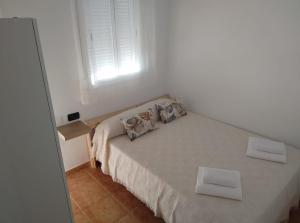 a bedroom with a bed with two pillows and a window at Sea view apartment in Alcalá in Alcalá