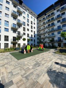a playground in front of a apartment building at Apartament Nowe Zatorze 92 in Olsztyn
