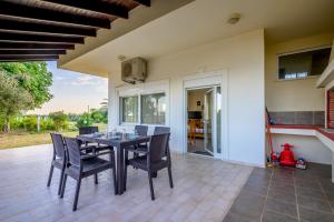 a dining room with a table and chairs on a patio at Sea view relaxing home in Mesimvría