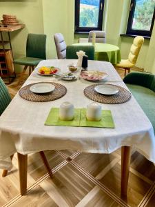 a table with a white table cloth and plates on it at Apartmány Na Výsluní České Švýcarsko in Dolní Podluží