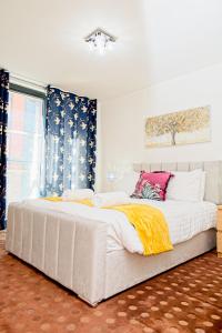 Una cama blanca grande en una habitación con ventana. en 2 Bedroom Chinatown Apartment, en Birmingham