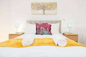 a bedroom with a white bed with towels on it at City Centre Apartment in Birmingham