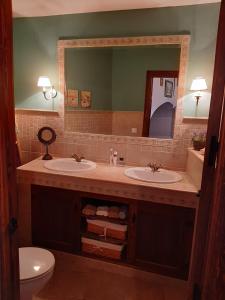 La salle de bains est pourvue de 2 lavabos et d'un miroir. dans l'établissement Casa Cueva Soledad, à Guadix