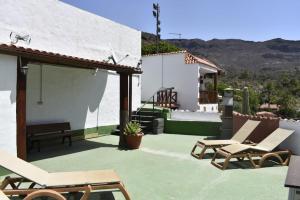 a patio with two lounge chairs and a house at Holiday Cottage Santa Lucía in Santa Lucía
