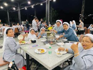 un grupo de personas sentadas en una mesa comiendo comida en Transformer Center Hotel en Batu