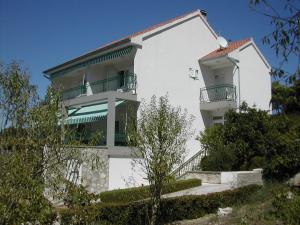 ein weißes Gebäude mit einem Balkon an der Seite in der Unterkunft Apartments by the sea Zlarin - 14025 in Zlarin