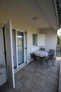 a patio with a table and chairs on a balcony at Apartments by the sea Zlarin - 14025 in Zlarin