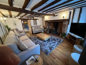 a living room with a couch and a flat screen tv at 4 Bedroom townhouse on one of the oldest streets in Wymondham