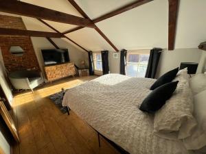 a bedroom with a bed and a tv in it at 4 Bedroom townhouse on one of the oldest streets in Wymondham