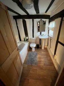 a bathroom with a tub and a toilet and a sink at 4 Bedroom townhouse on one of the oldest streets in Wymondham