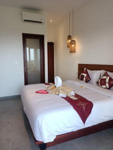 a bedroom with two beds with white sheets at The Kd Suites & Coffee Shop in Munggu