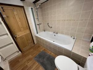 a bathroom with a toilet and a bath tub at 4 Bedroom townhouse on one of the oldest streets in Wymondham