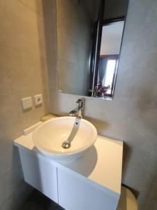 a bathroom with a white sink and a mirror at The Kd Suites & Coffee Shop in Munggu