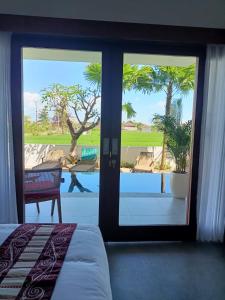 a bedroom with a sliding glass door with a view of a pool at The Kd Suites & Coffee Shop in Munggu