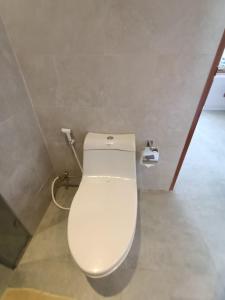 a bathroom with a white toilet in a room at The Kd Suites & Coffee Shop in Munggu