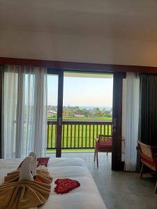 a hotel room with two beds and a balcony at The Kd Suites & Coffee Shop in Munggu