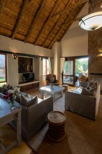 een woonkamer met banken en een tafel bij Leopard's Lair Bush Lodge in Hoedspruit