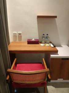 a desk with a red chair under a table at The Kd Suites & Coffee Shop in Munggu