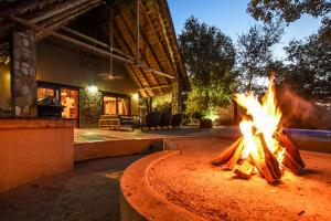 a fire pit in front of a house at Leopard's Lair Bush Lodge in Hoedspruit