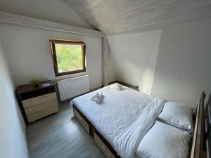 a small bedroom with a bed and a window at Vila Enjoy in Văliug