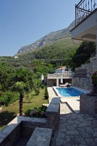 a backyard with a swimming pool and a palm tree at Villa Sveta in Petrovac na Moru