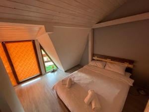 a bedroom with a bed with two towels on it at Vila Enjoy in Văliug