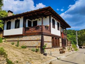 una casa con balcone sul lato di Rimovata Kashta Guest House a Leshten